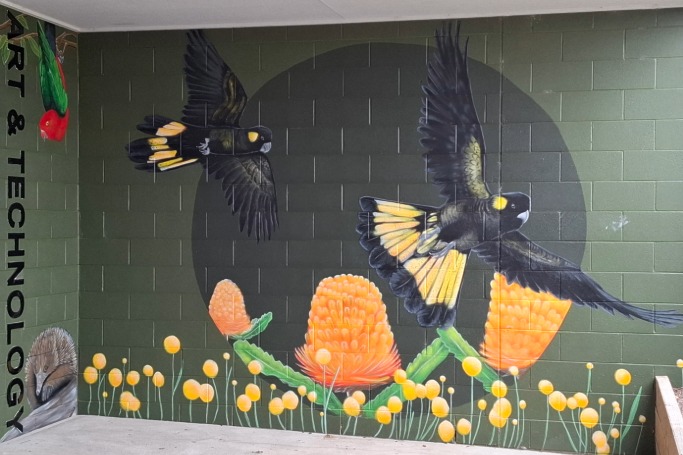 School mural with two black birds painted on the wall