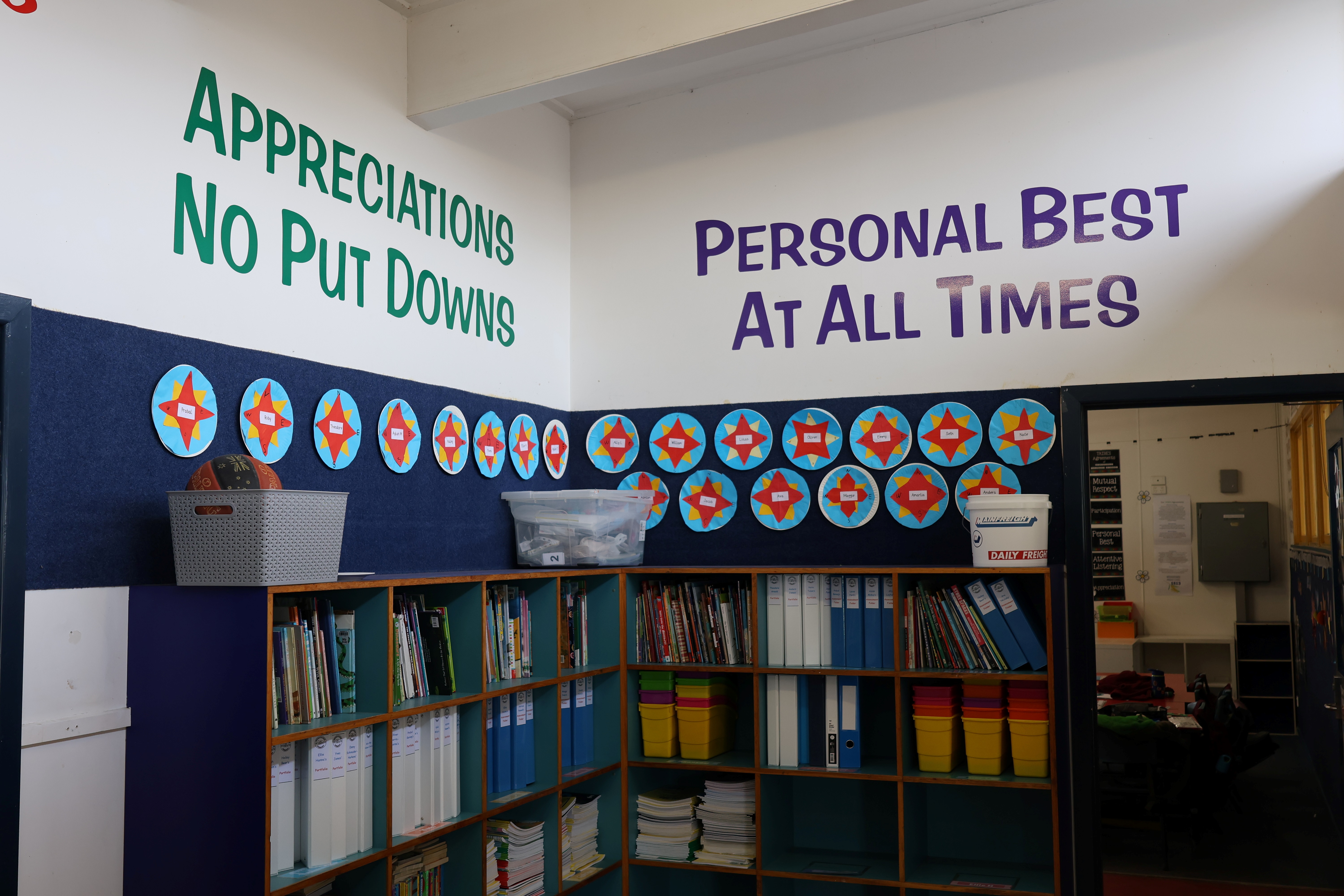 Shelves with appreciations no put downs and personal best at all times printed on the wall