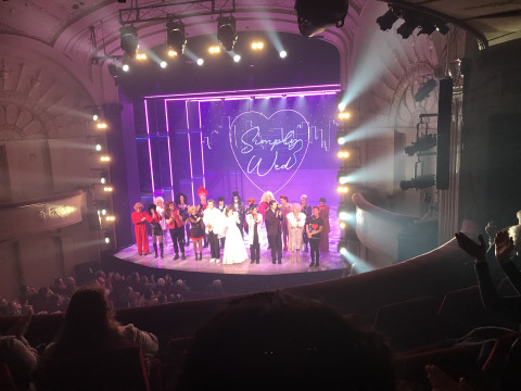 A photo of the stage full of actors in a theatre 